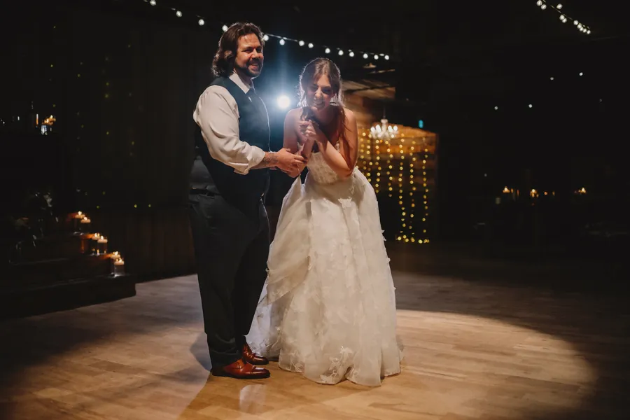 Le couple rit sous un projecteur sur la piste de danse