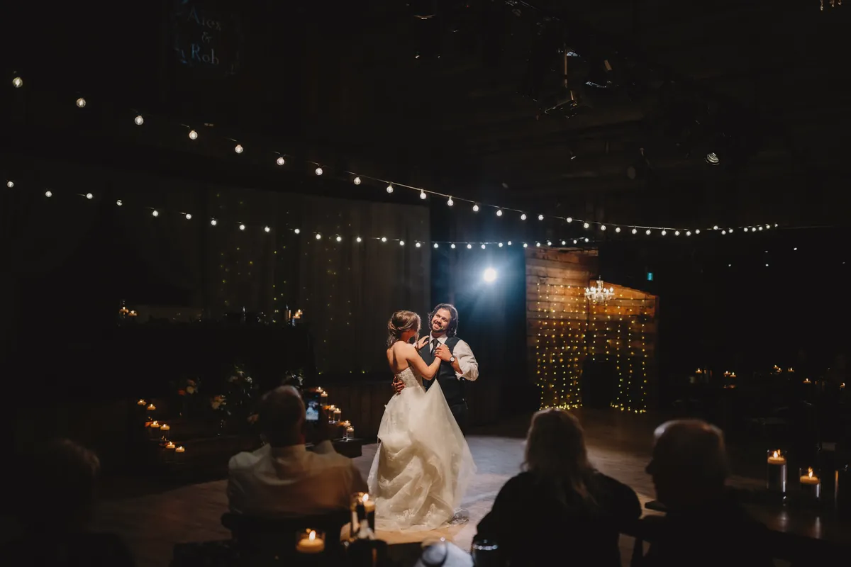 Première danse du couple sous des guirlandes lumineuses, dans une salle sombre (Version finale de Gabe)