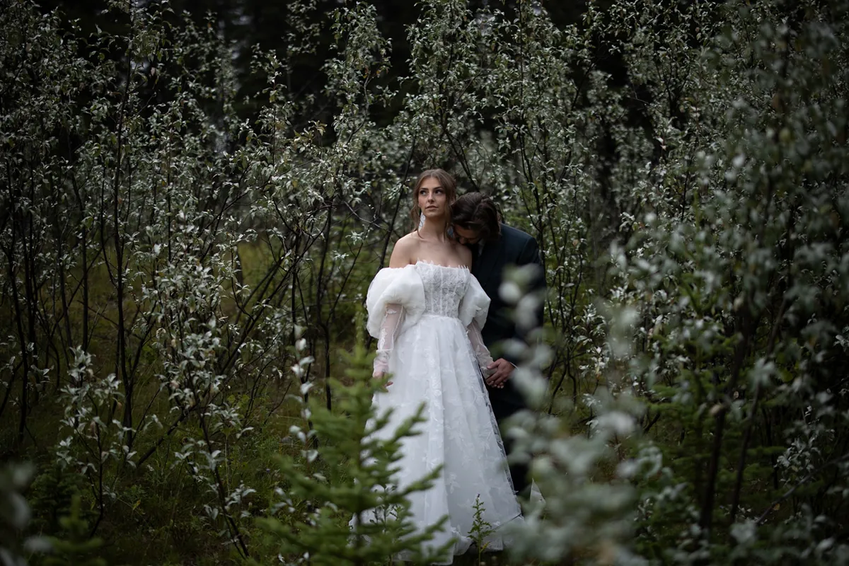La mariée debout dans un fourré de fleurs sauvages blanches (Originale)