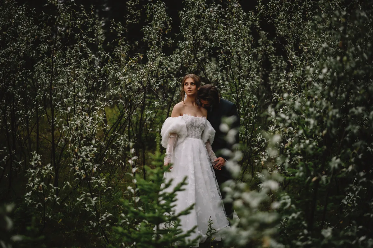 La mariée debout dans un fourré de fleurs sauvages blanches (Retouche PHAiTO)