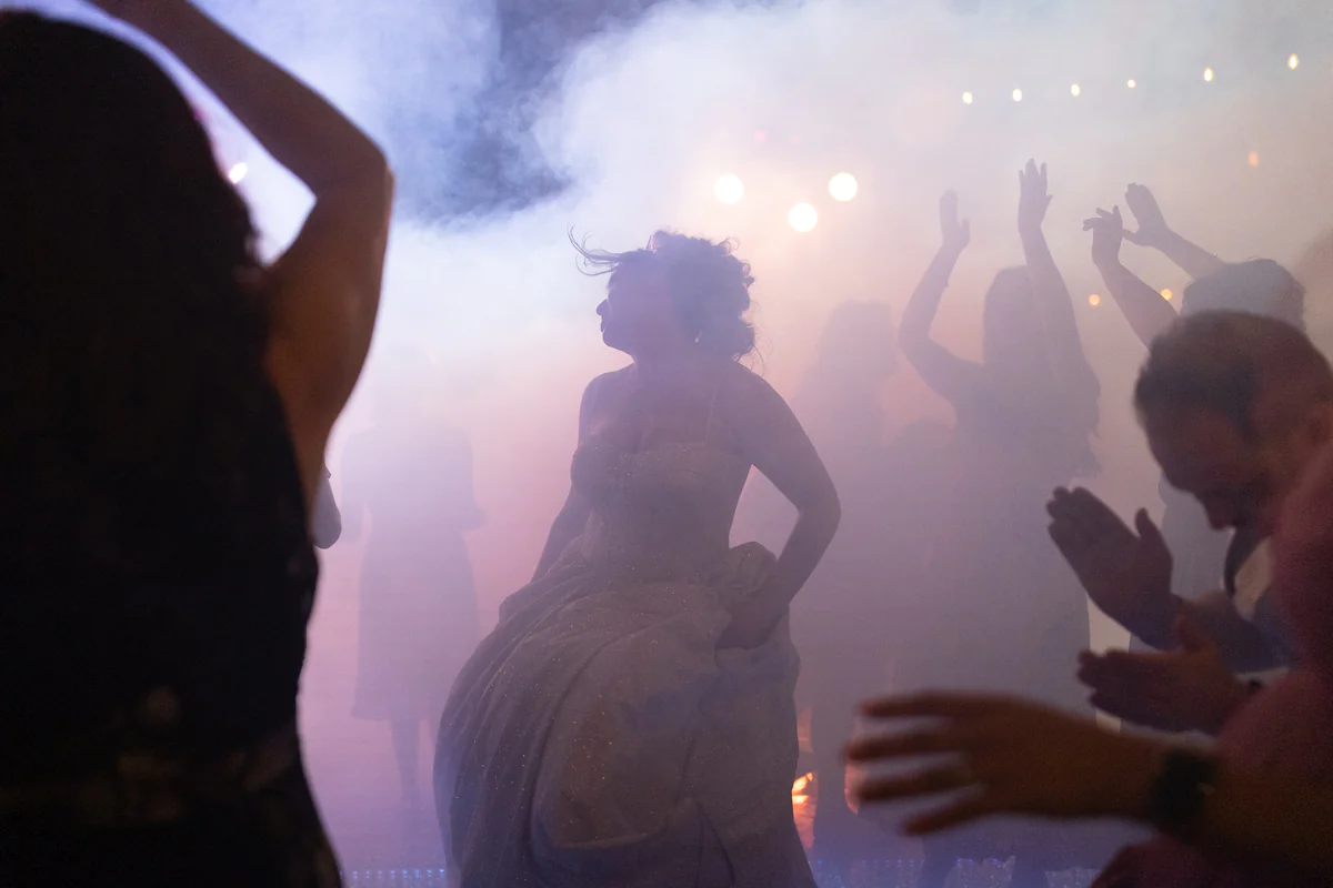 La mariée danse dans la fumée tourbillonnante et les lumières colorées sous les acclamations des invités (Originale)
