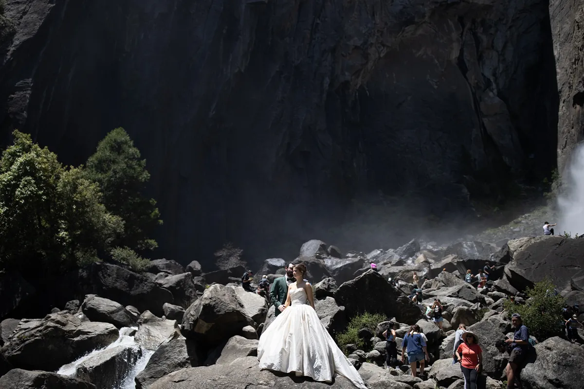 Couple sur un champ de rochers, dans l'ombre profonde, près d'une chute lumineuse (Originale)